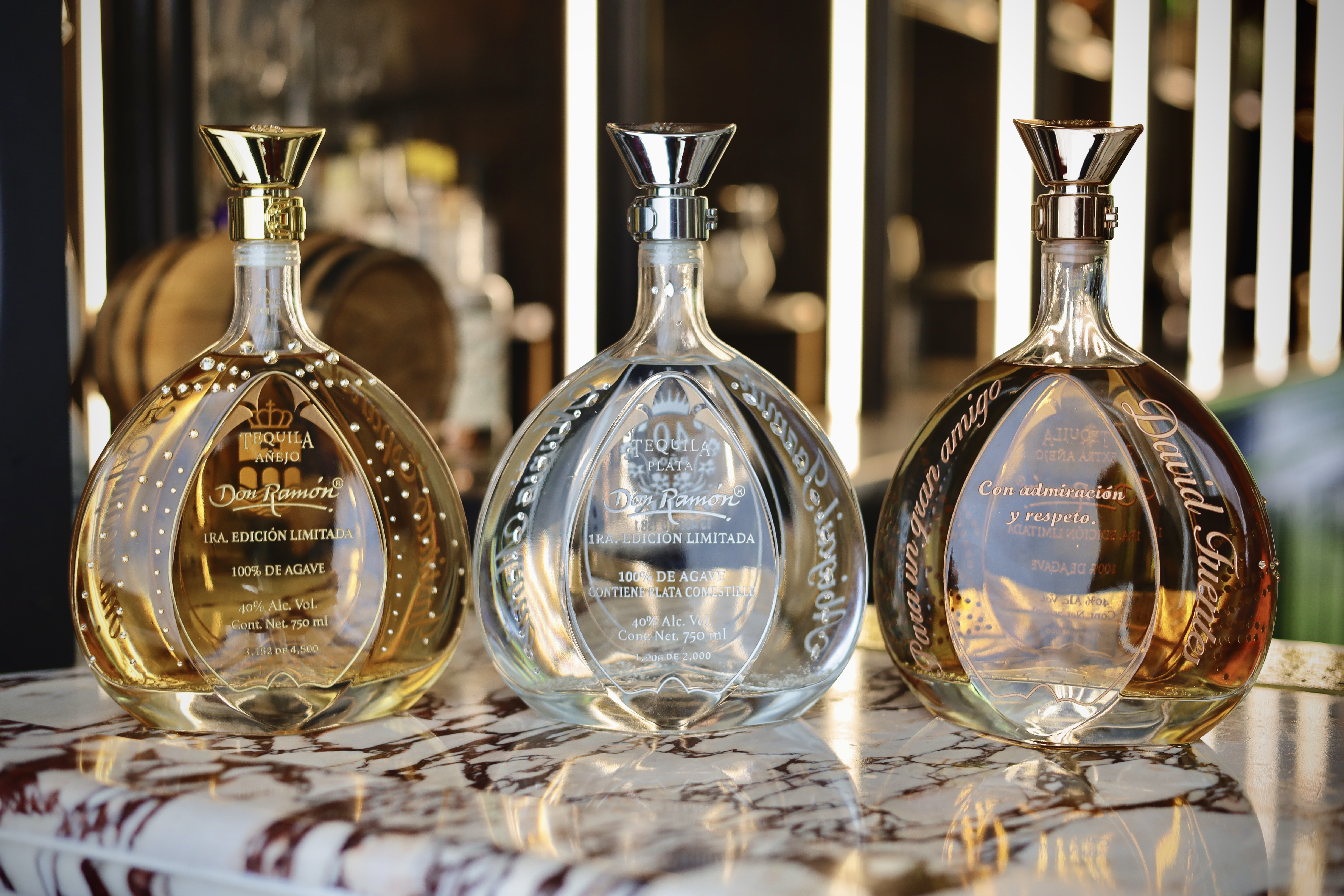 Imagen de fondo de casa Metl sobre una barra de madera con muchas botellas de tequila de fondo.